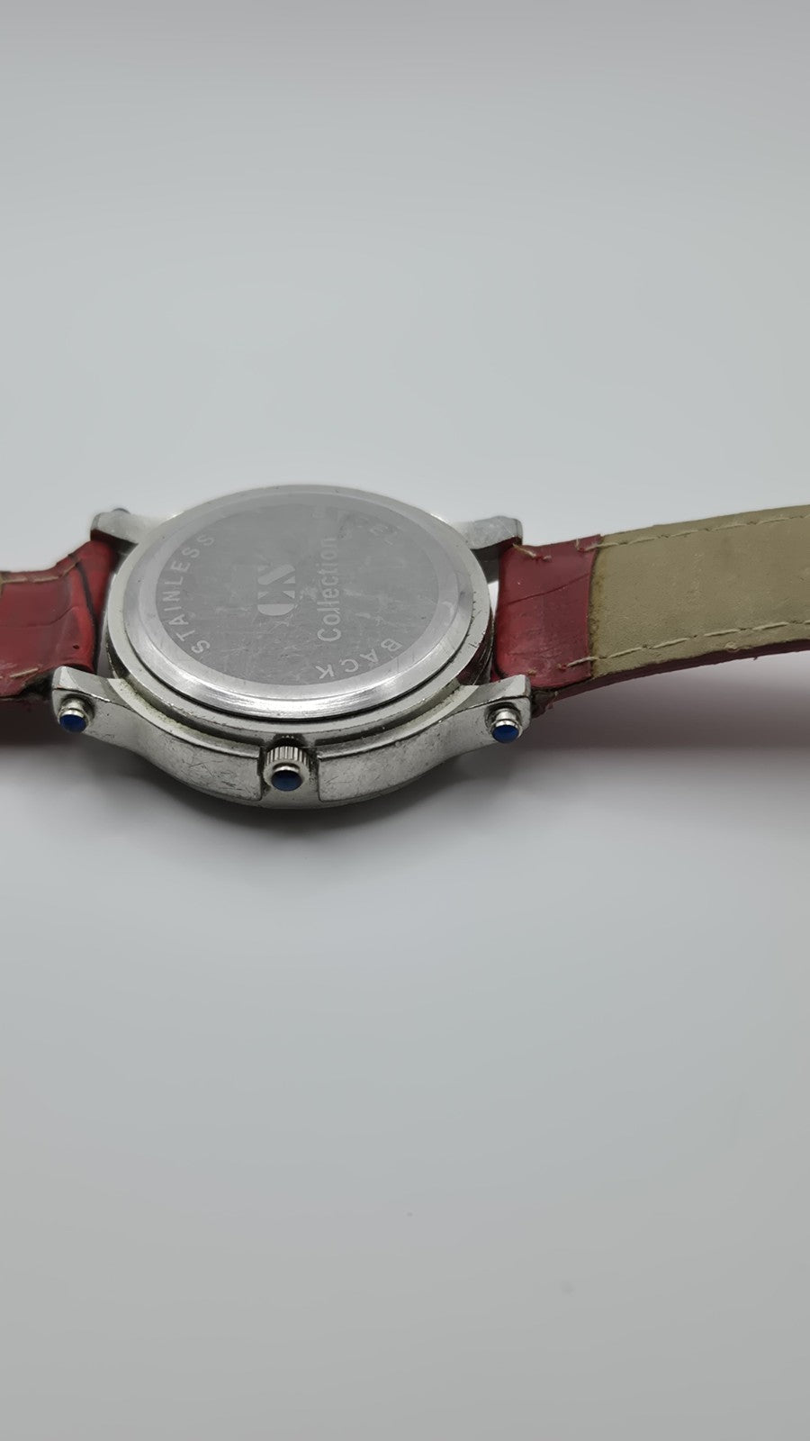 CS Collection Quartz watch with a red band and a crystalstudded bezel.6