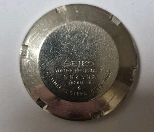 Vintage stainless steel case back from a Seiko 6139-7002 watch0