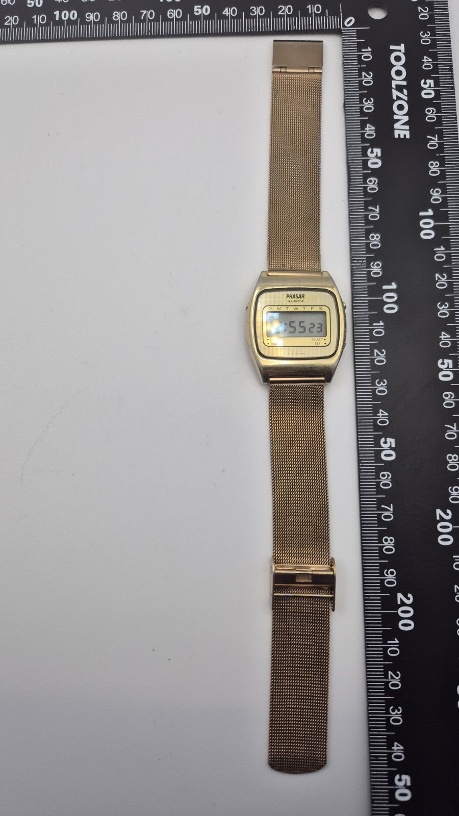 Phasar Quartz digital watch features a gold-tone metal case with wear on the...4