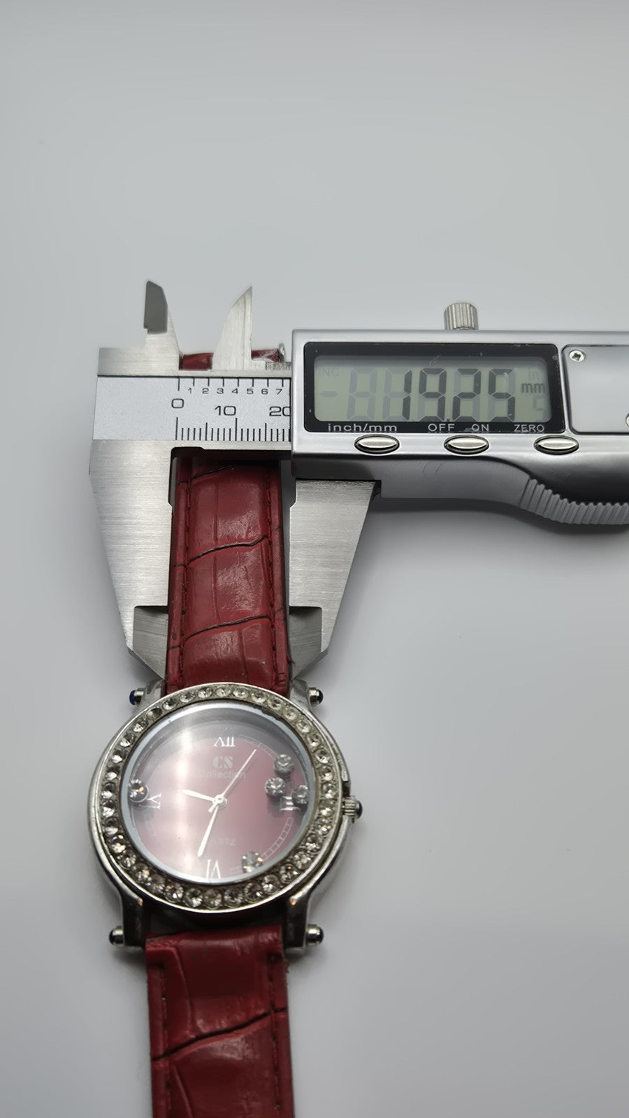 CS Collection Quartz watch with a red band and a crystalstudded bezel.11