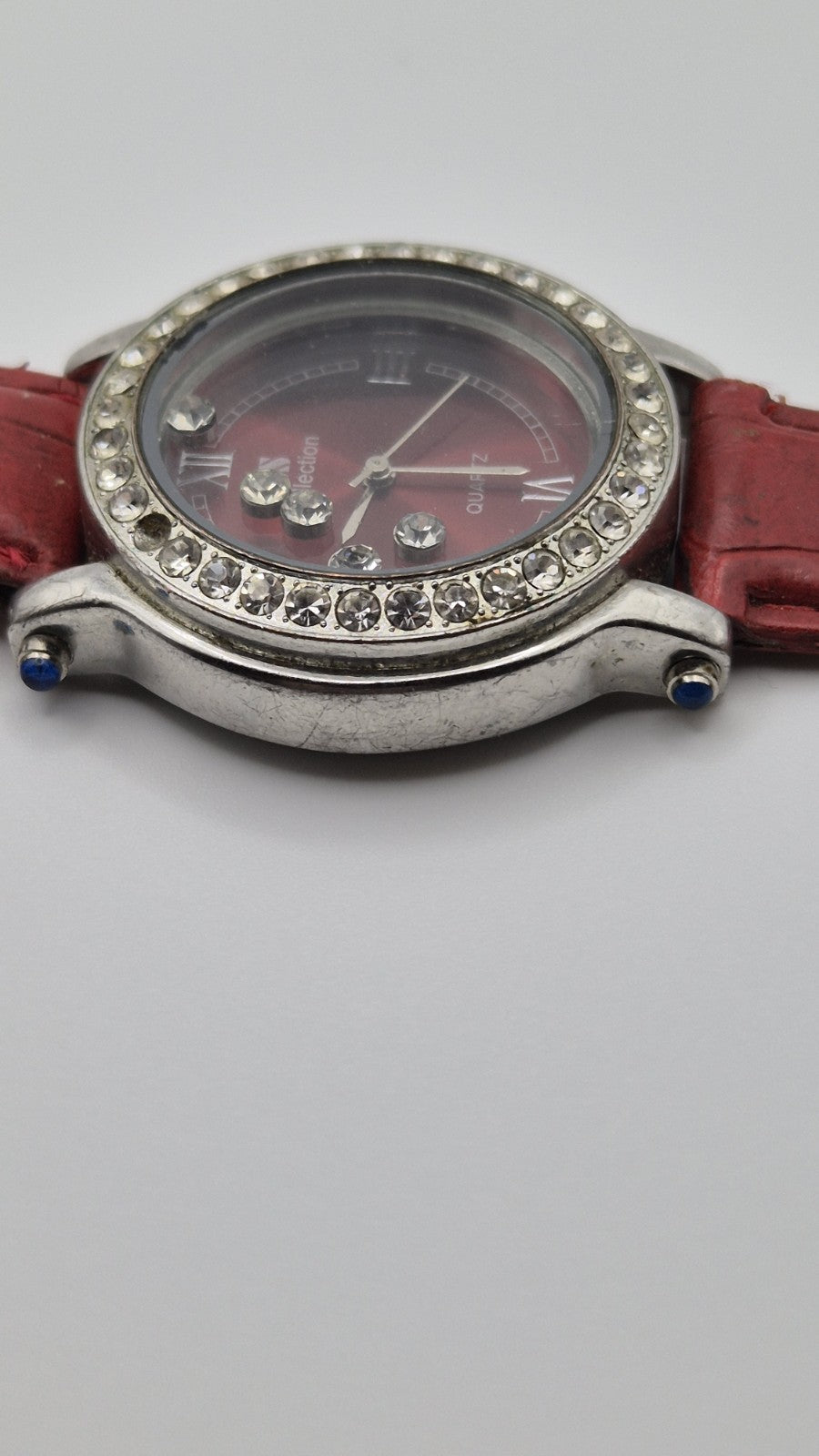 CS Collection Quartz watch with a red band and a crystalstudded bezel.1
