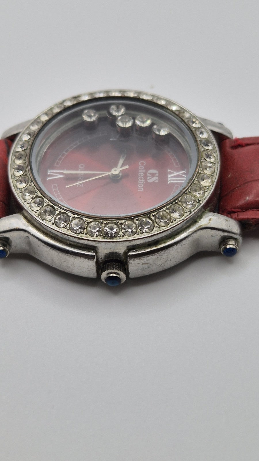 CS Collection Quartz watch with a red band and a crystalstudded bezel.2