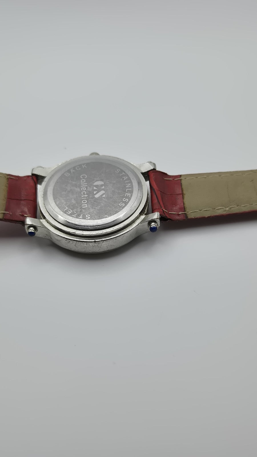 CS Collection Quartz watch with a red band and a crystalstudded bezel.8