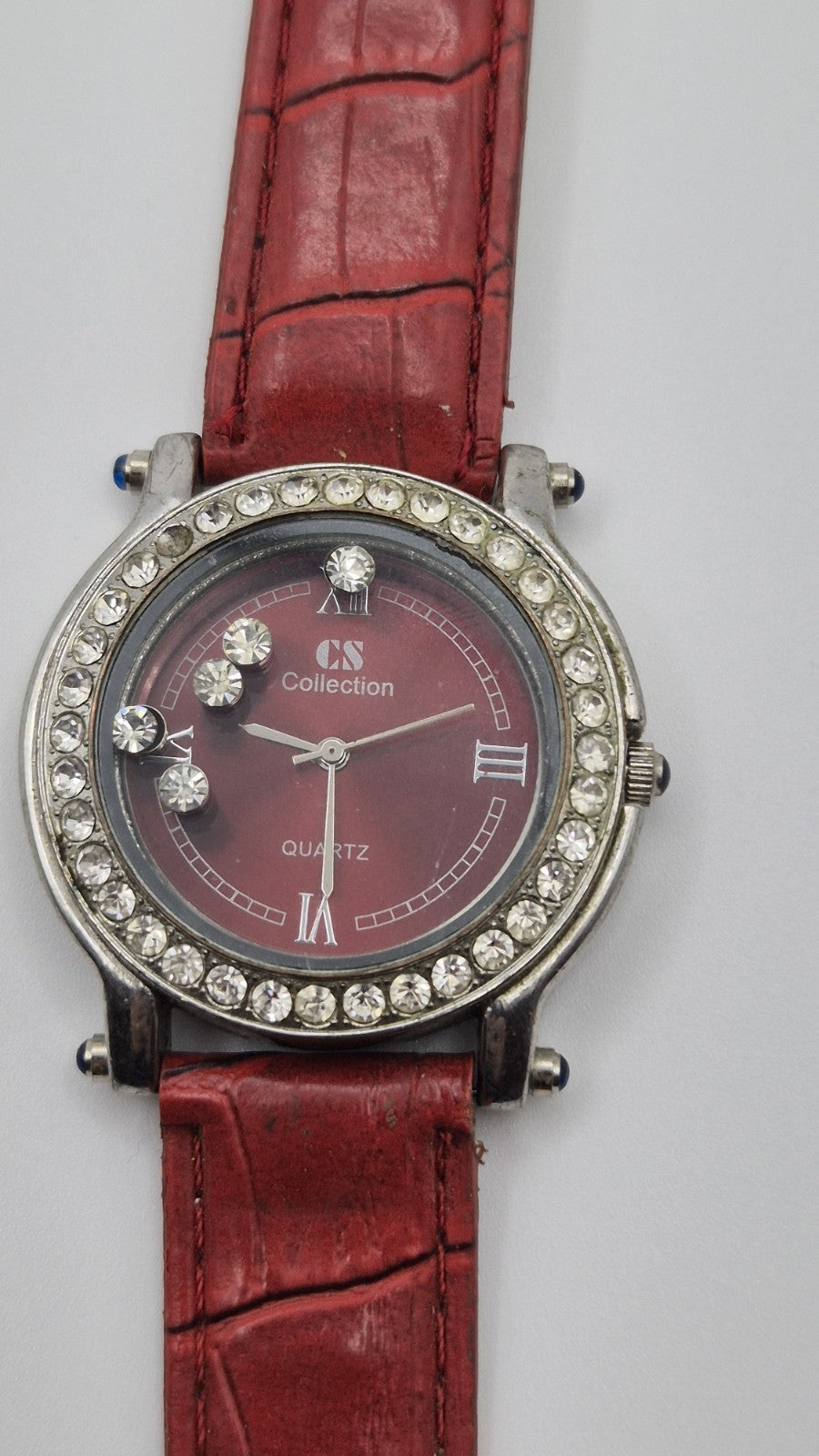 CS Collection Quartz watch with a red band and a crystalstudded bezel.0
